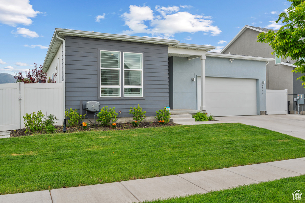 View of front of house with concrete driveway and an attached garage