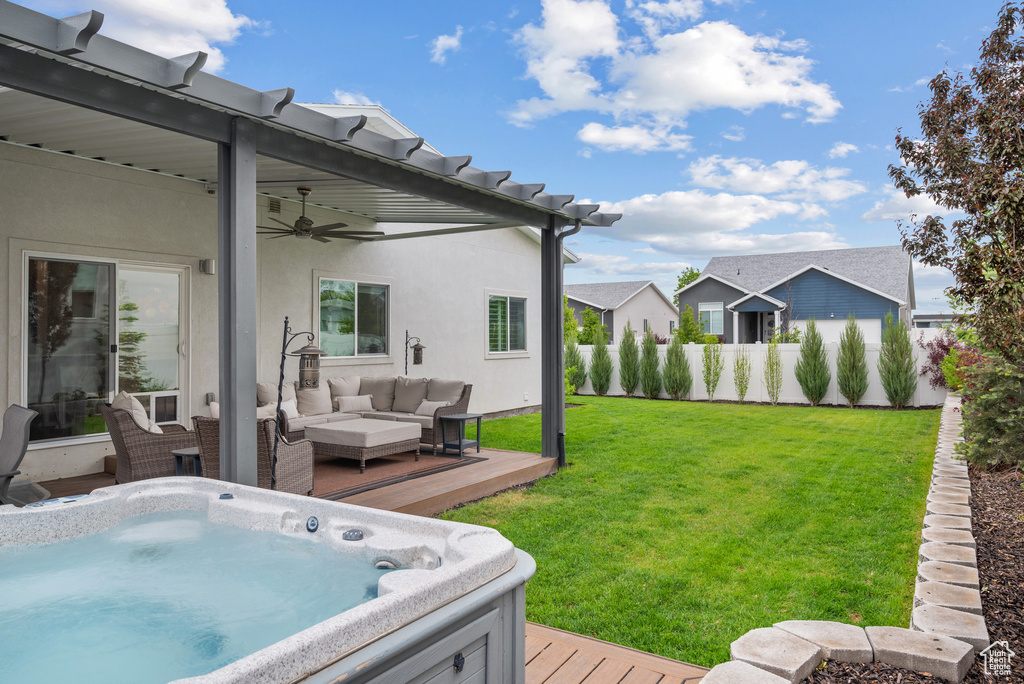 View of yard featuring a deck, an outdoor living space, a ceiling fan, and a hot tub