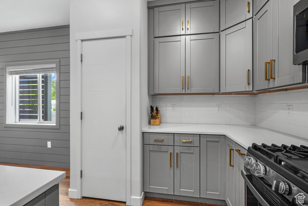 Kitchen with gray cabinets, light countertops, and appliances with stainless steel finishes