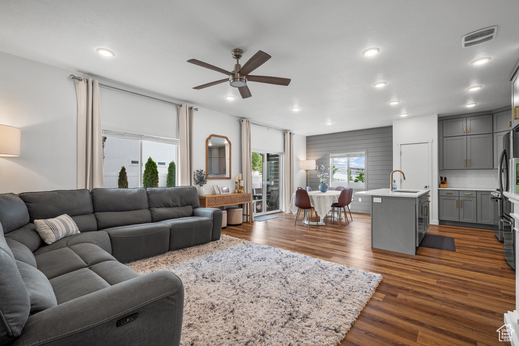 Living area featuring a ceiling fan, dark wood finished floors, and recessed lighting