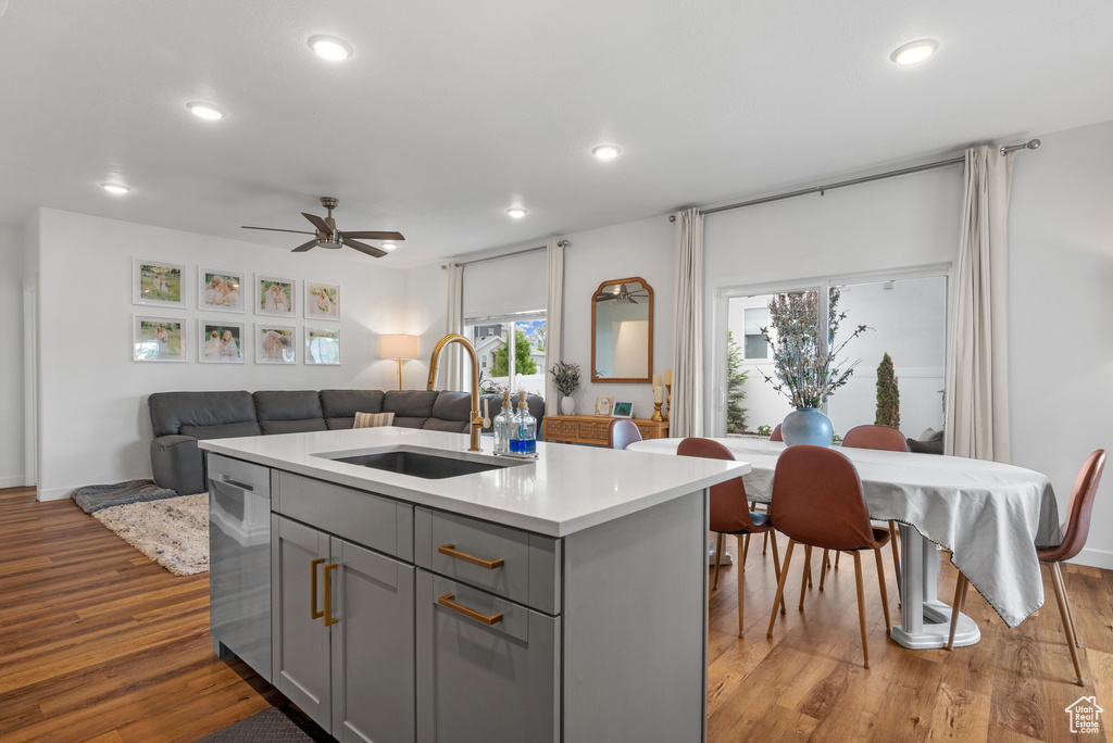 Kitchen with gray cabinets, a sink, dishwasher, recessed lighting, and light countertops