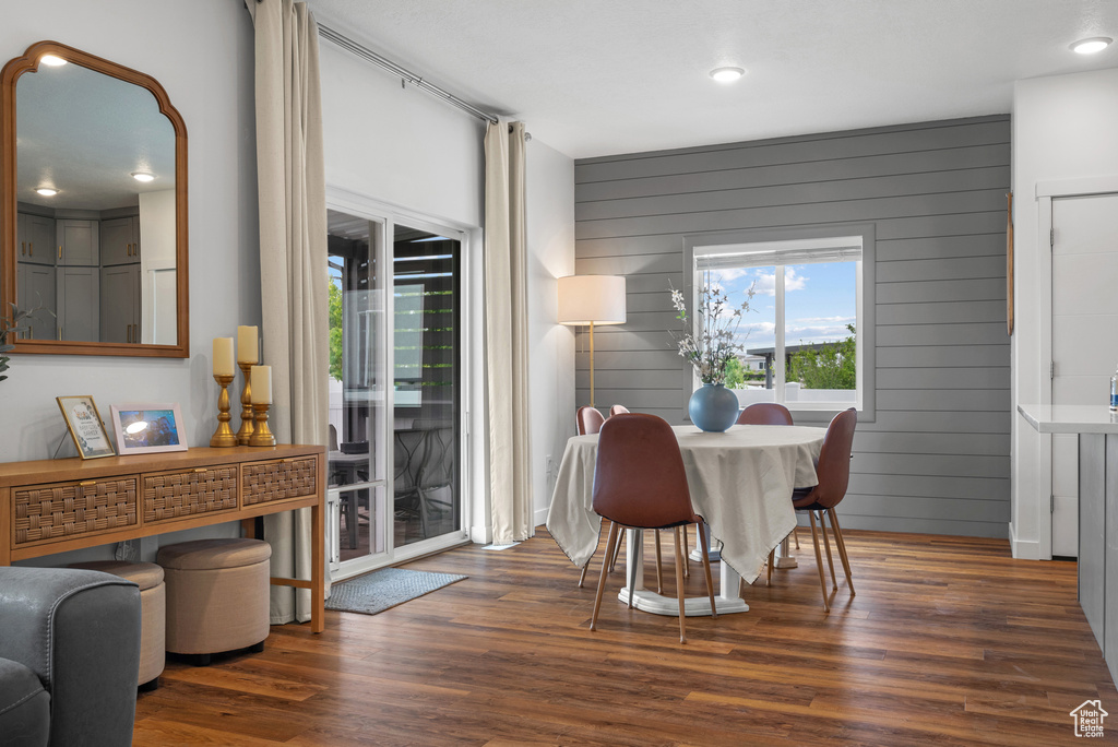 Dining room with wood finished floors, wood walls, and recessed lighting