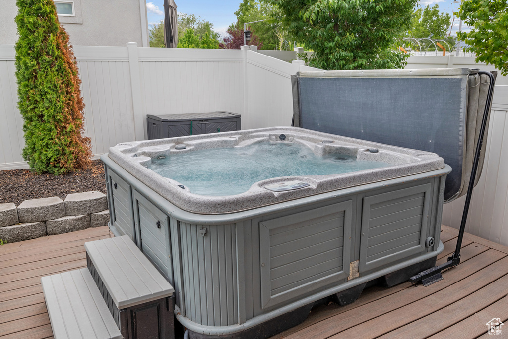 Wooden terrace with a hot tub and fence