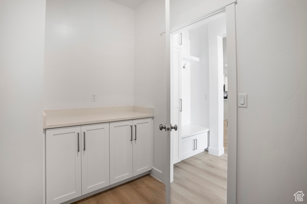 Hall featuring light wood-style flooring and baseboards