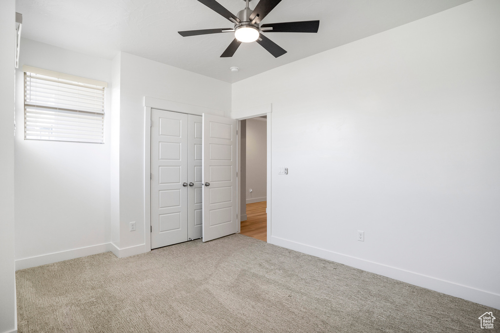 Unfurnished bedroom with carpet flooring, baseboards, a closet, and ceiling fan