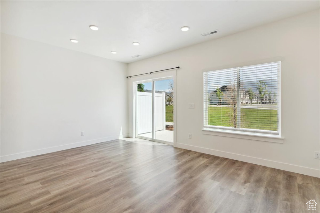 Spare room featuring wood finished floors, recessed lighting, and baseboards