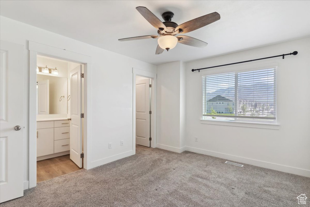 Unfurnished bedroom featuring carpet, baseboards, connected bathroom, and ceiling fan