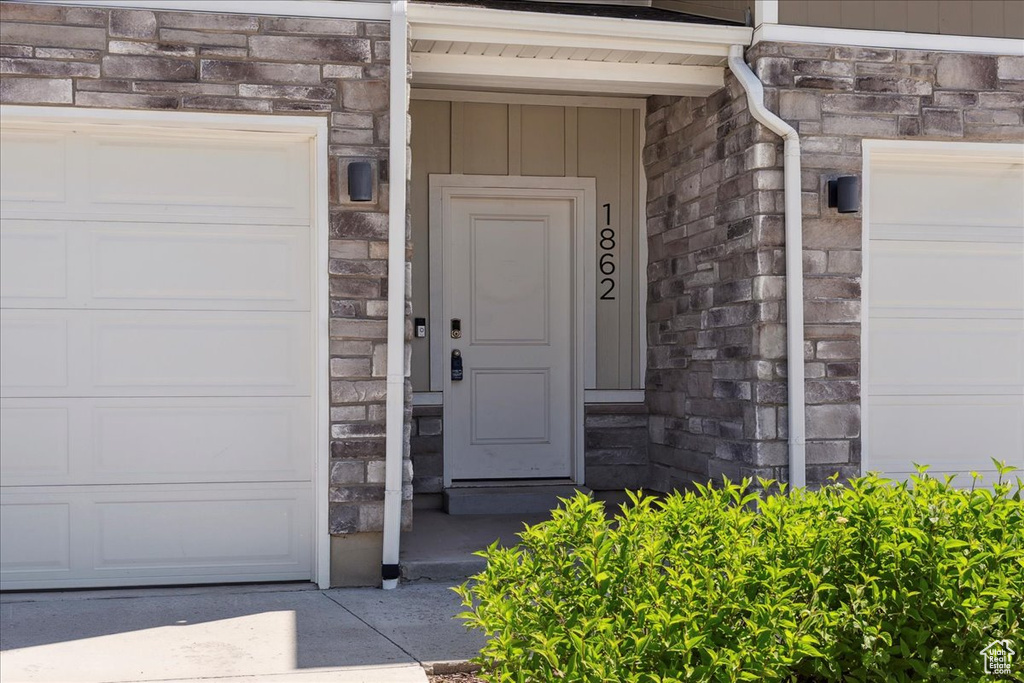 Doorway to property with stone siding and board and batten siding