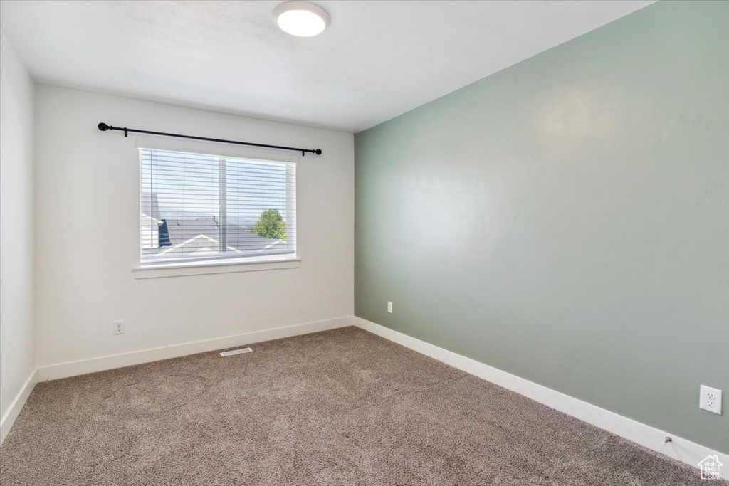 Carpeted spare room with baseboards