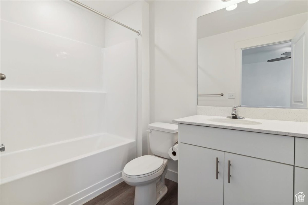 Full bath with vanity, wood finished floors, toilet, and shower / bathtub combination