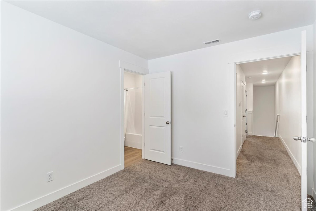 Carpeted spare room with a smoke detector and baseboards