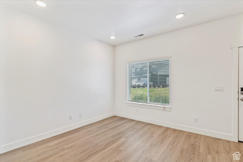 Spare room with light wood-style flooring, baseboards, and recessed lighting