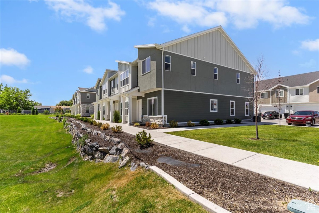 View of home's exterior with board and batten siding, a yard, and a residential view