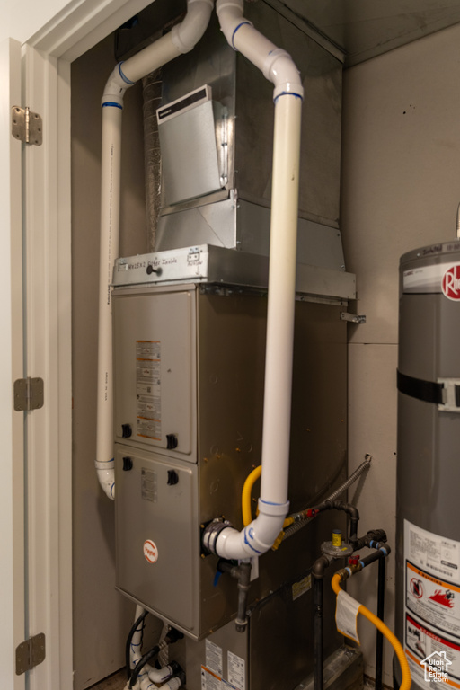 Utility room with strapped water heater and heating unit