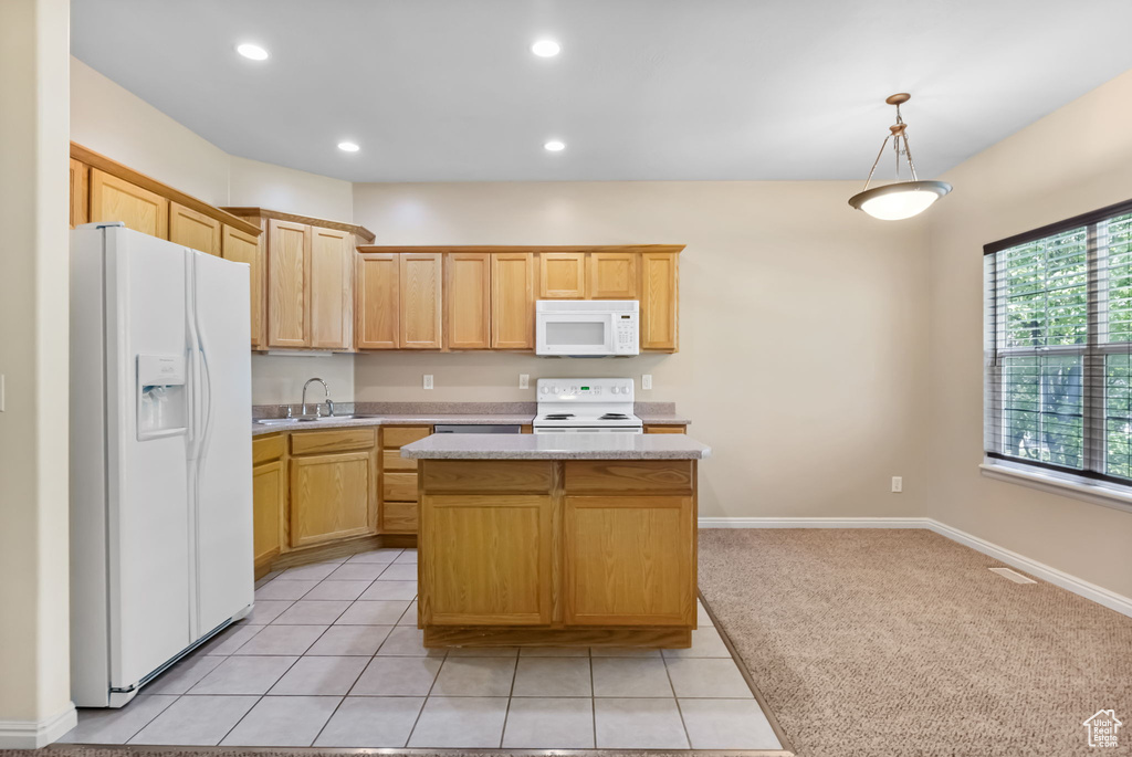 Kitchen featuring white appliances, a kitchen island, a sink, recessed lighting, and hanging light fixtures