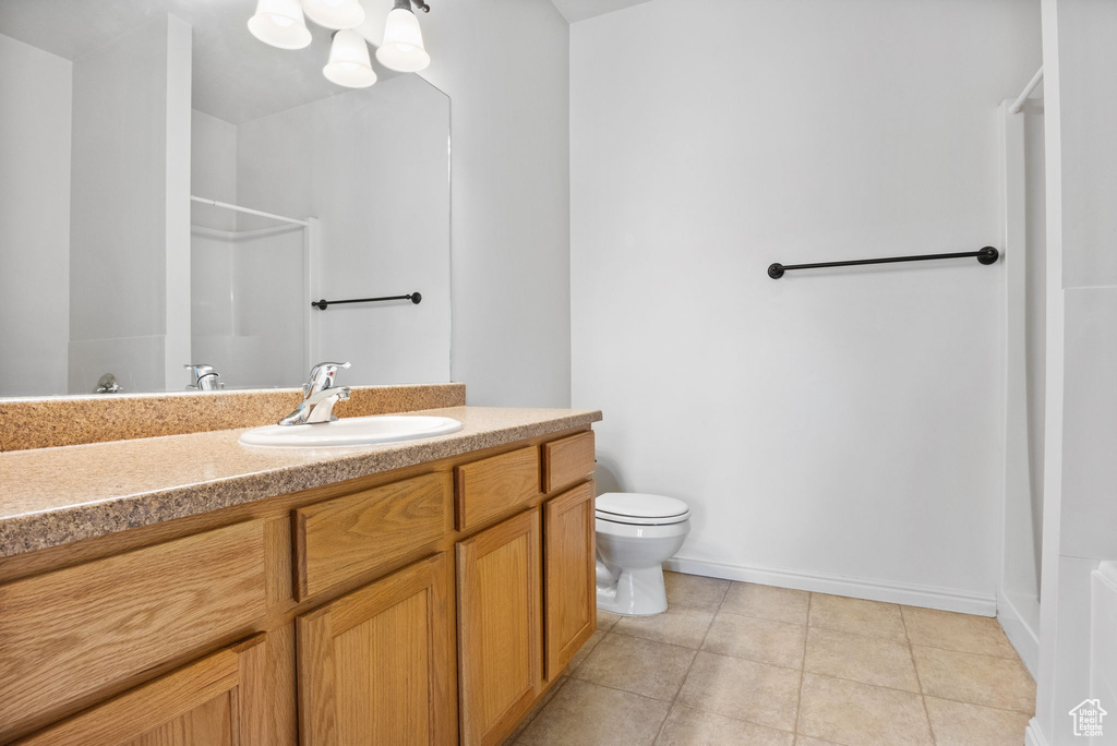 Full bathroom with a shower, tile patterned flooring, toilet, vanity, and baseboards