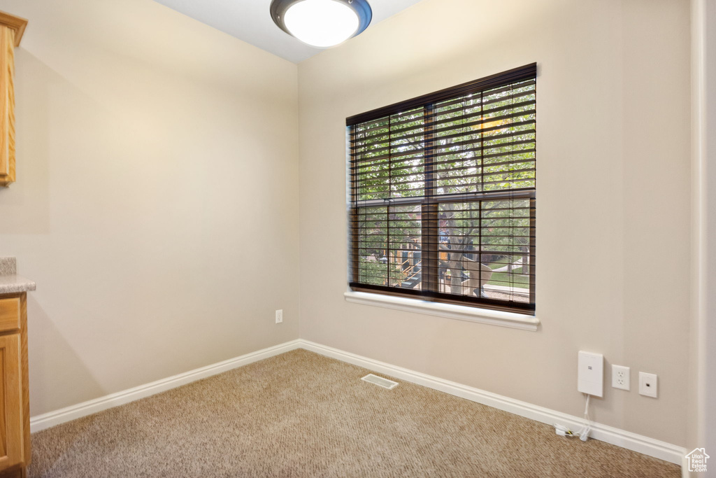 Carpeted spare room with baseboards