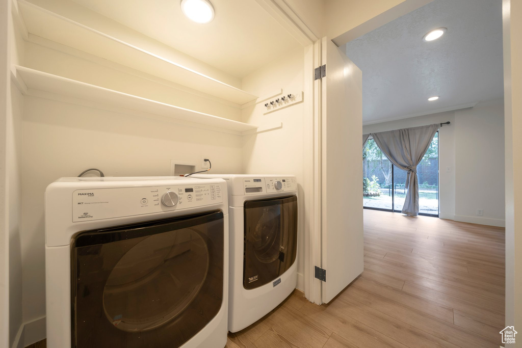 Laundry area with washing machine and dryer, light wood-type flooring, and recessed lighting