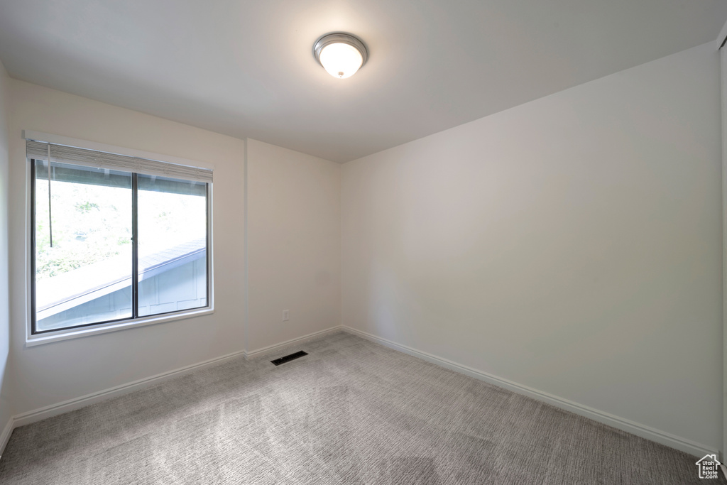 Carpeted spare room with baseboards