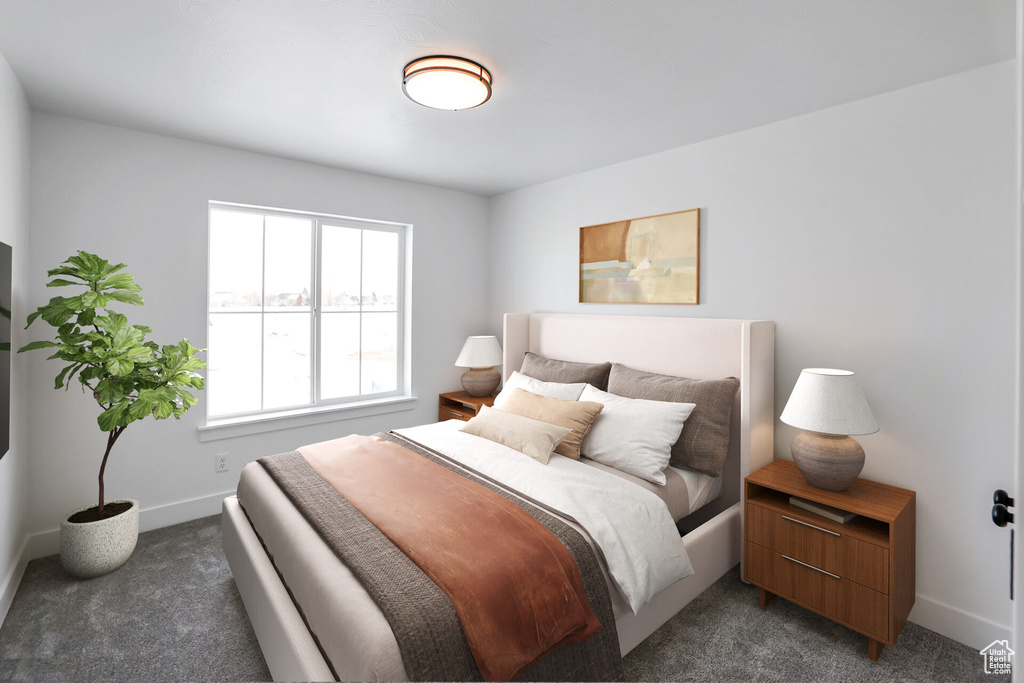 Bedroom featuring dark carpet and baseboards