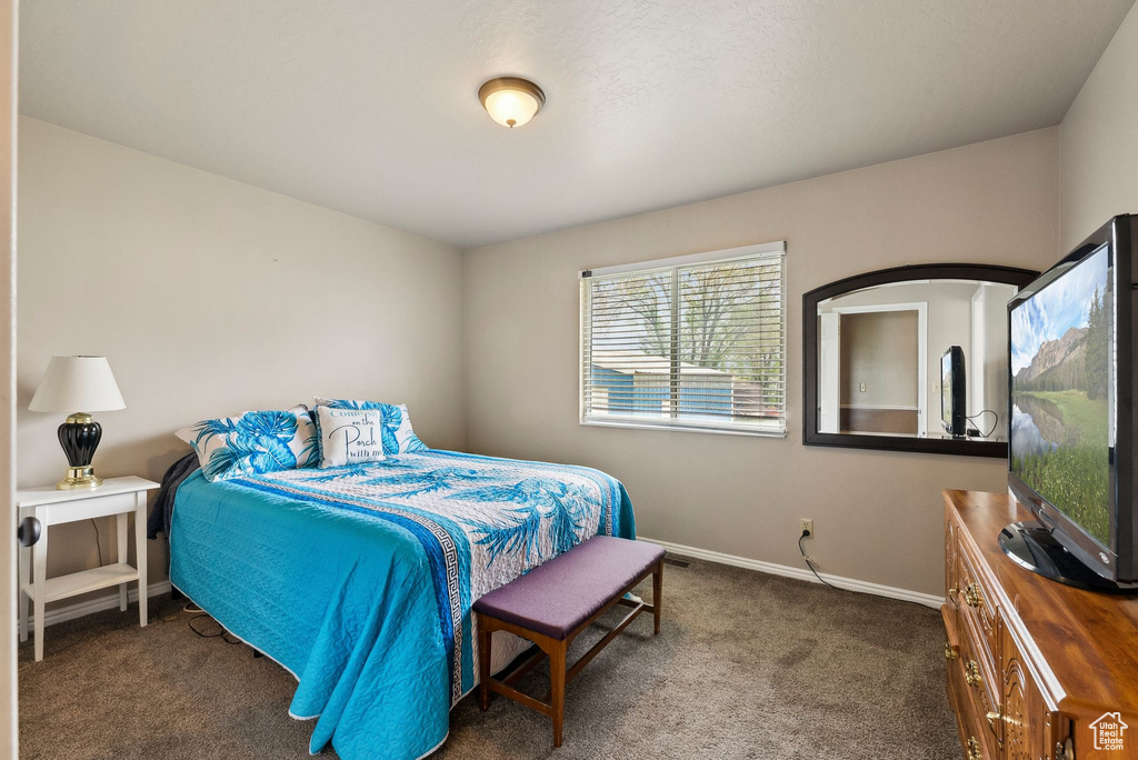 Bedroom featuring carpet and baseboards