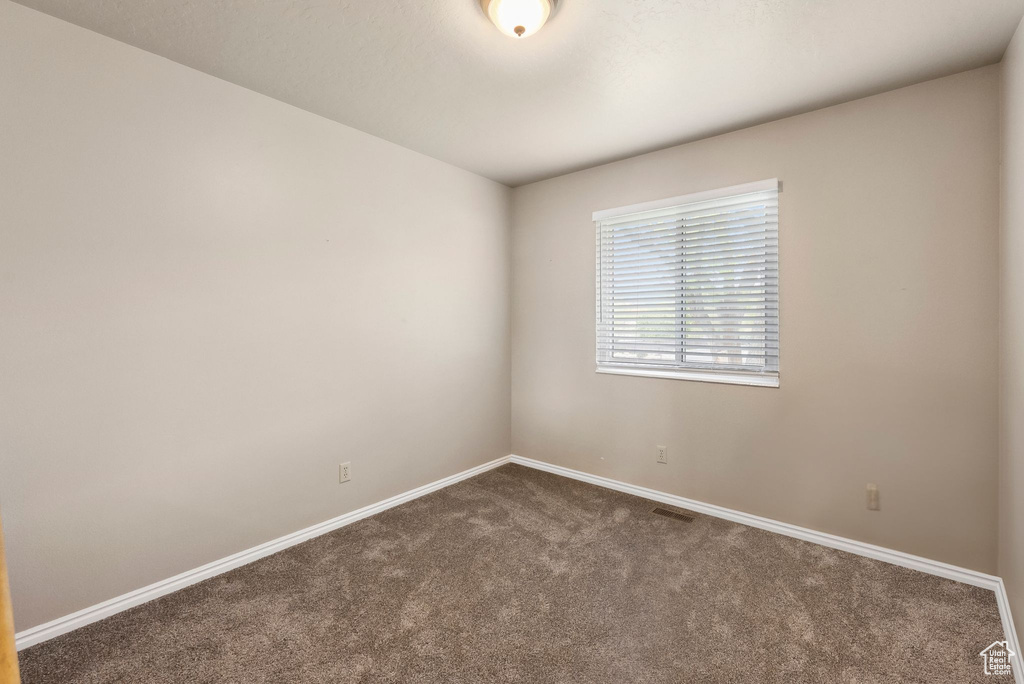 Carpeted empty room with baseboards