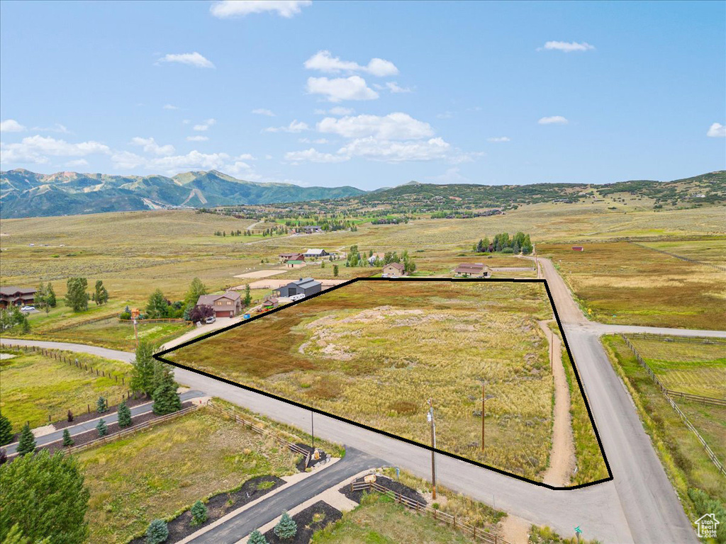 Aerial view of sparsely populated area featuring property parcel outlined and a mountain backdrop