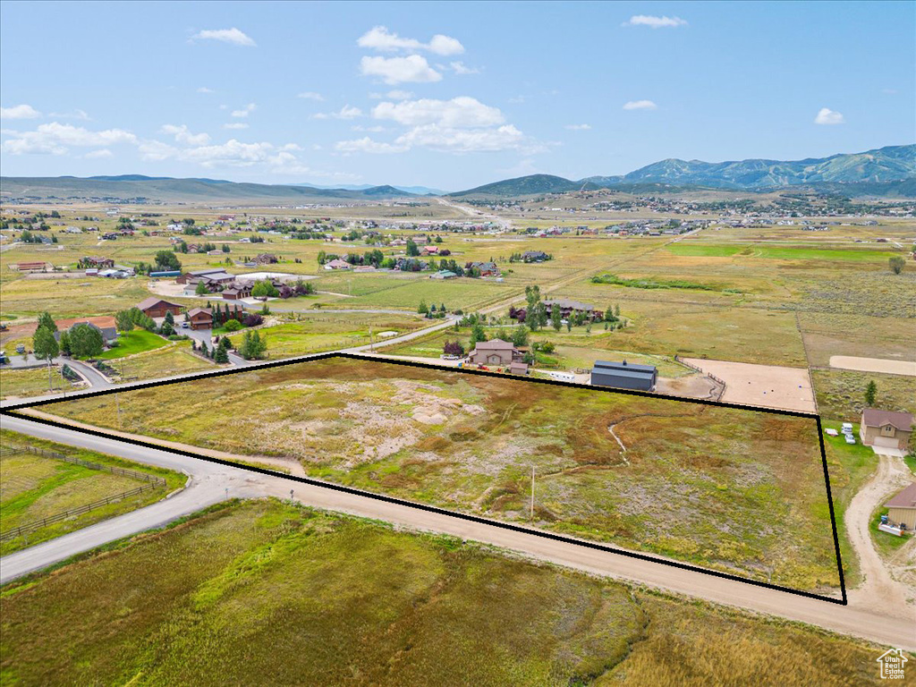 Aerial view of property and surrounding area with mountains and property parcel outlined