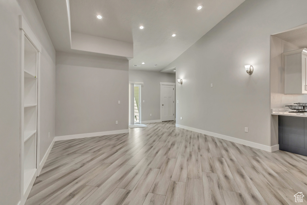 Unfurnished living room with recessed lighting, light wood-style floors, and baseboards