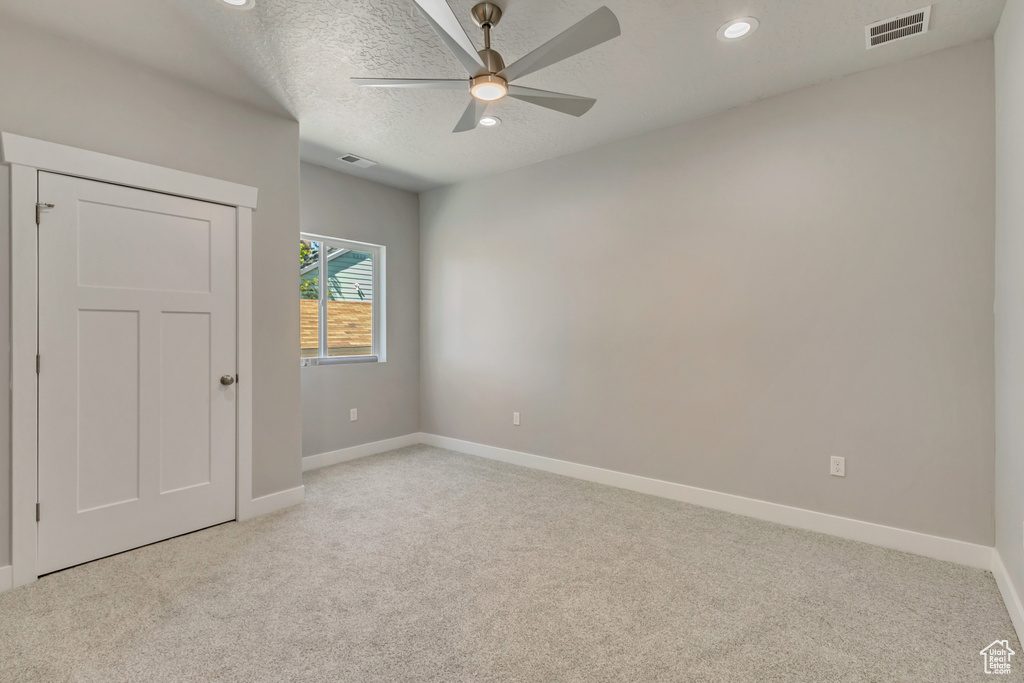Spare room with light carpet, baseboards, a ceiling fan, recessed lighting, and a textured ceiling
