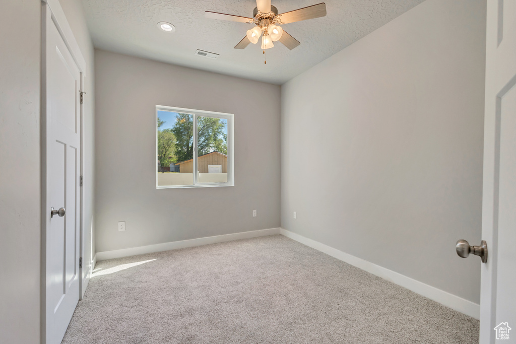 Unfurnished bedroom featuring carpet floors, a textured ceiling, baseboards, and ceiling fan