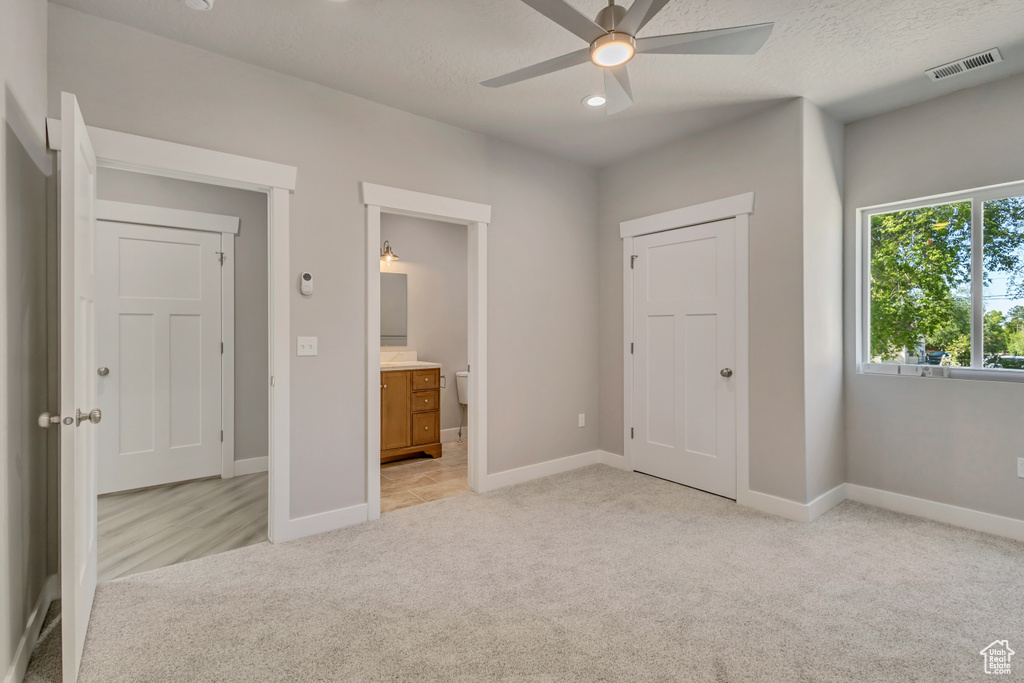 Unfurnished bedroom featuring light colored carpet, baseboards, ensuite bathroom, and recessed lighting