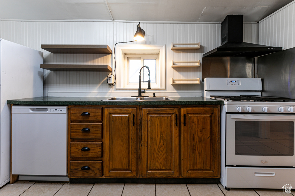 Kitchen featuring open shelves, white appliances, wall chimney range hood, and a sink