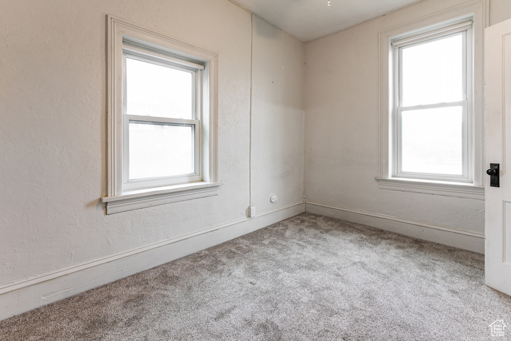 Carpeted empty room with healthy amount of natural light