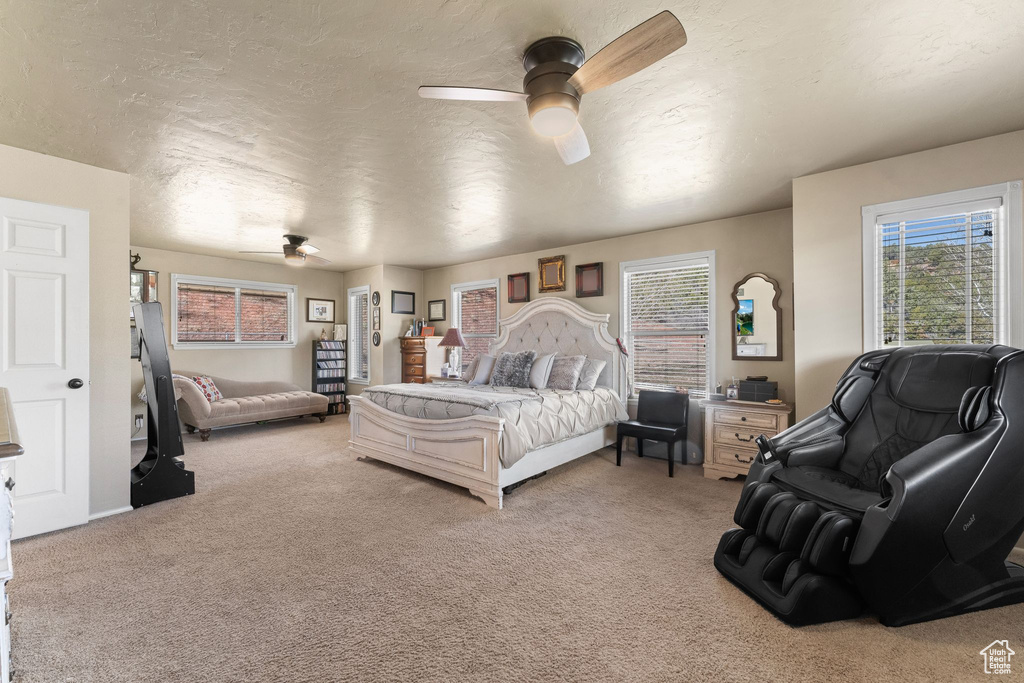 Bedroom featuring light colored carpet, a ceiling fan, and a textured ceiling