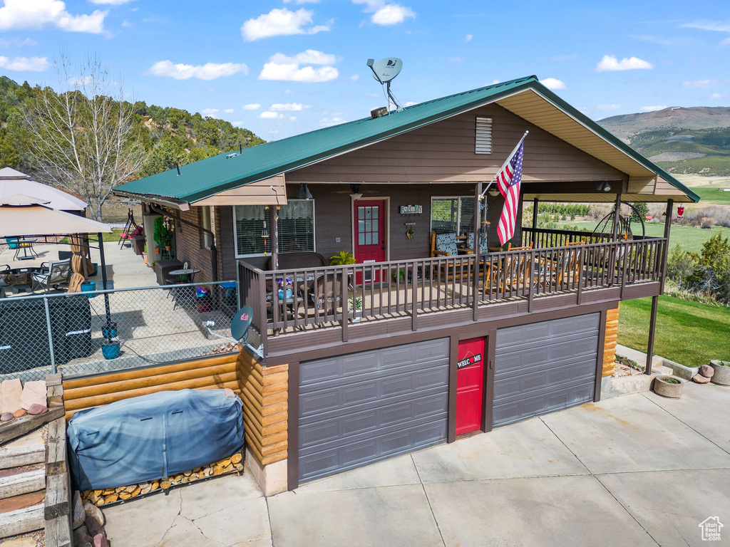 View of front of home with driveway, a garage, a mountain view, and a gazebo