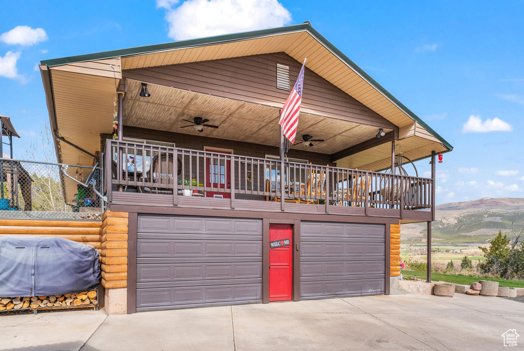 View of front of house featuring concrete driveway, a garage, a mountain view, and a ceiling fan