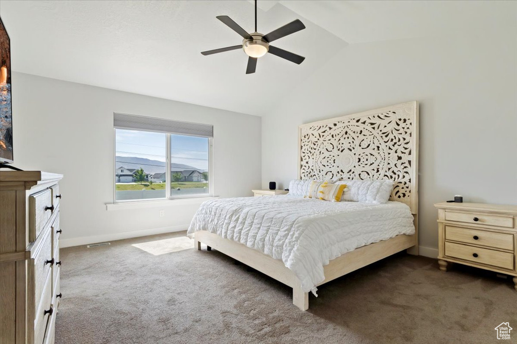 Bedroom featuring dark carpet, lofted ceiling, baseboards, and ceiling fan