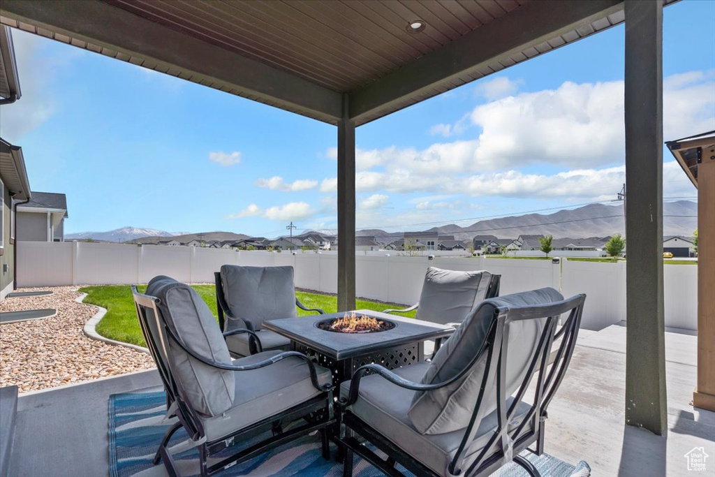 View of patio / terrace with an outdoor fire pit, a fenced backyard, a mountain view, and a residential view
