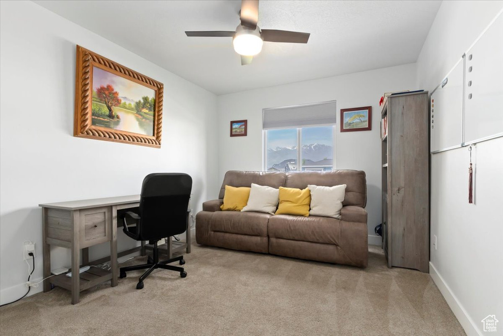 Carpeted office featuring a ceiling fan and baseboards