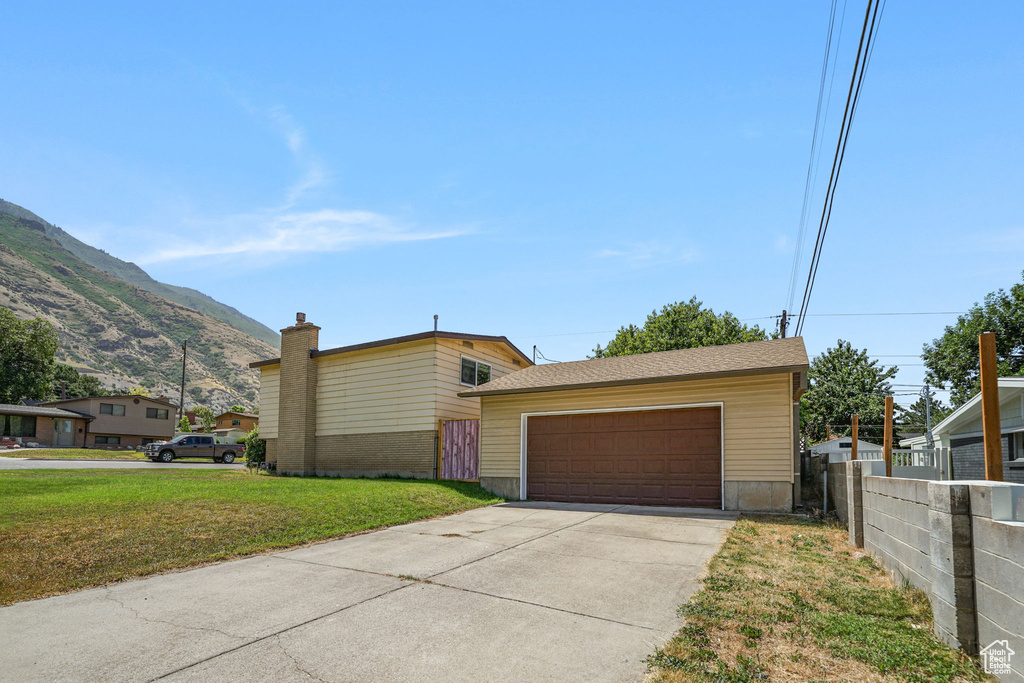 View of side of property with a detached garage and a mountain view
