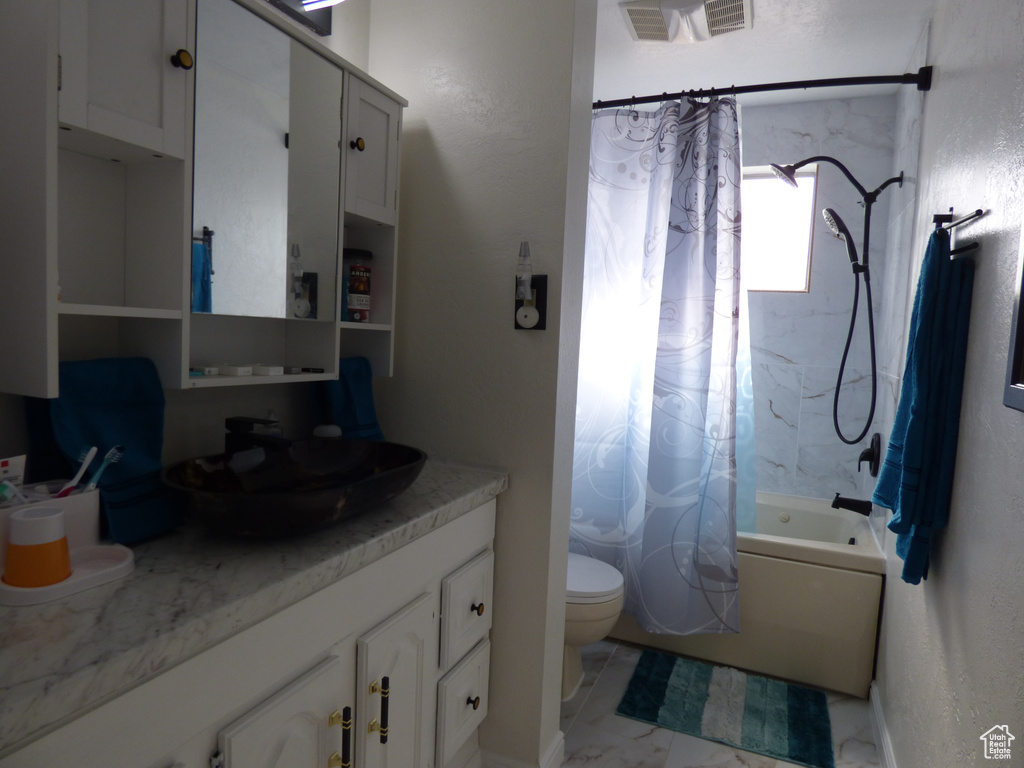 Full bath featuring shower / tub combo, vanity, toilet, and marble look tile flooring