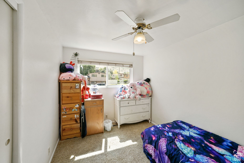 Carpeted bedroom featuring a ceiling fan and baseboards