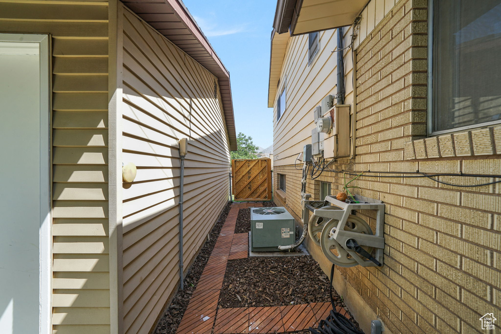 View of side of property featuring a central AC unit and brick siding