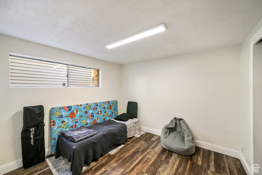 Bedroom featuring wood finished floors and a textured ceiling
