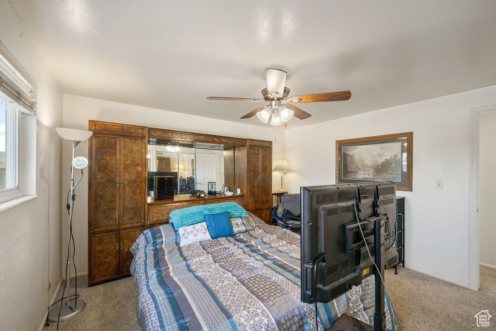 Carpeted bedroom featuring baseboards and ceiling fan