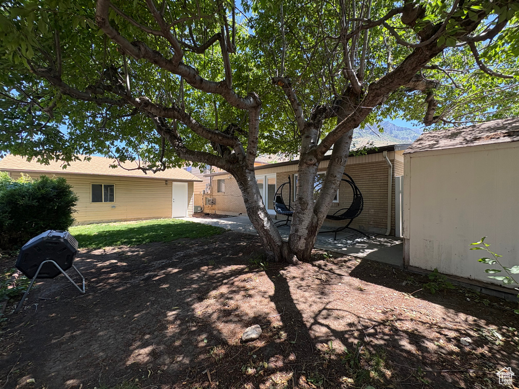 View of yard featuring a garage and a patio