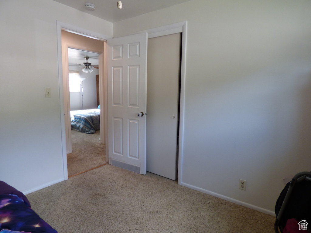 Bedroom with light carpet, a closet, and baseboards