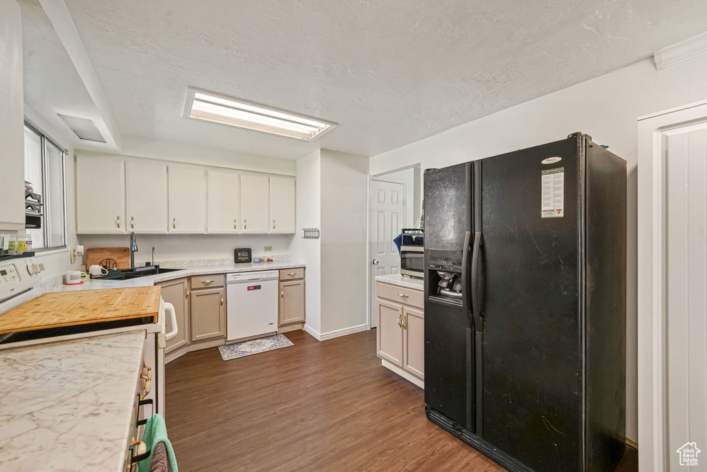 Kitchen with white appliances, dark wood-style flooring, light countertops, and white cabinetry