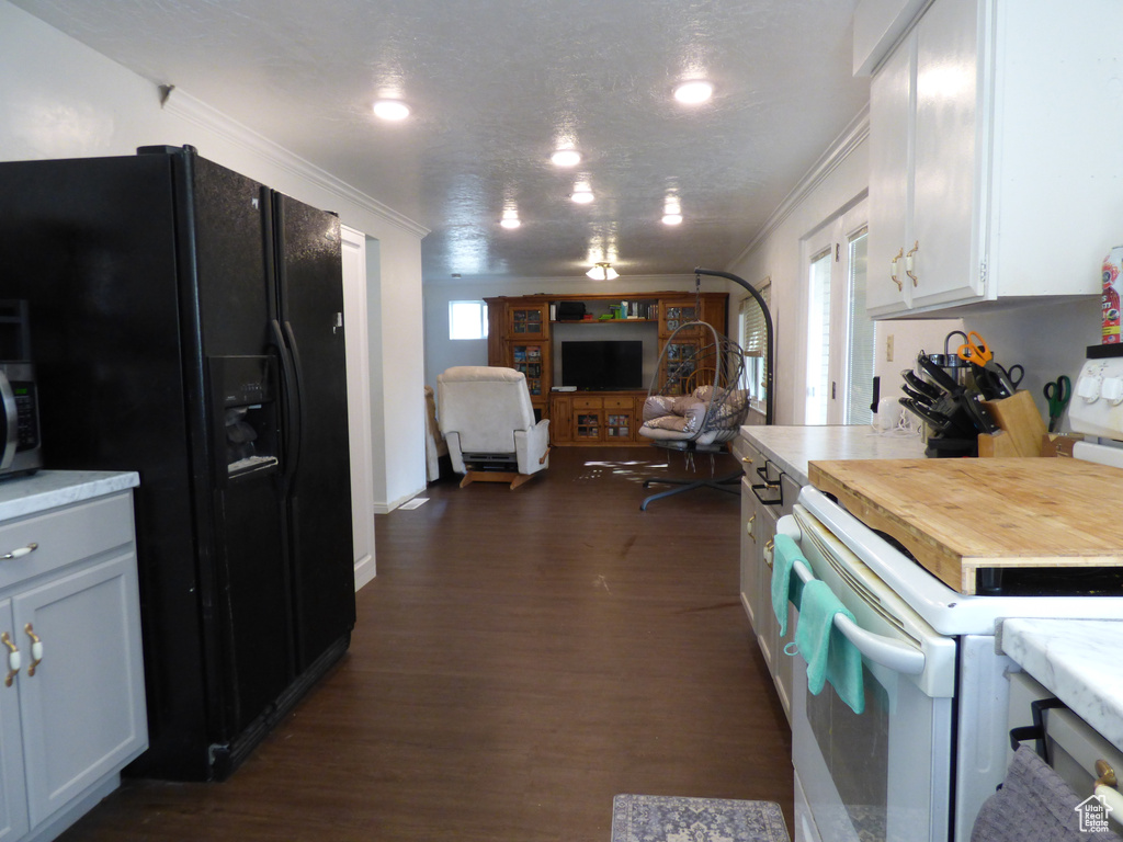 Kitchen featuring electric stove, black fridge with ice dispenser, ornamental molding, dark wood-style flooring, and light countertops